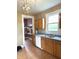 Well-lit kitchen with wood cabinets, a white dishwasher, and a view of an adjacent storage area at 660 N 700 E, Whitestown, IN 46075