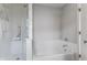 Bright bathroom with white tile, a glass-enclosed shower, and a soaking tub at 6665 Boxcar Pl, Indianapolis, IN 46220