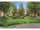 Lush, grassy setting with mature trees and manicured bushes in front of well-maintained townhouses at 6665 Boxcar Pl, Indianapolis, IN 46220
