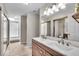 Bright bathroom featuring a double sink vanity, tile flooring, and a glass-enclosed shower at 6916 Ralph Ct, Indianapolis, IN 46220