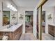 Well-lit bathroom with a double vanity and a view into the bedroom at 6916 Ralph Ct, Indianapolis, IN 46220