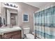 Well-lit bathroom featuring a modern vanity, stylish mirror and a decorative blue patterned shower curtain at 6916 Ralph Ct, Indianapolis, IN 46220
