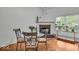 Bright dining area with a fireplace, large windows, hardwood floors and stylish table set at 6916 Ralph Ct, Indianapolis, IN 46220