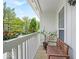 Charming outdoor patio with views of mature trees, white railings, and a bench for seating at 6916 Ralph Ct, Indianapolis, IN 46220