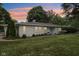 Charming house exterior with well-manicured lawn, garden beds, and light blue accents at 7277 N College Ave, Indianapolis, IN 46240