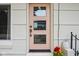 Charming pink front door with windows, flower pot and stylish handle at 7277 N College Ave, Indianapolis, IN 46240