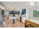 Open-concept kitchen featuring stainless steel appliances, blue cabinets, and eat-in dining area at 7277 N College Ave, Indianapolis, IN 46240