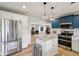 Open kitchen features granite countertops, island, stainless appliances, and a view into the Gathering room at 7277 N College Ave, Indianapolis, IN 46240