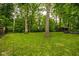 Spacious backyard with lush lawn, mature trees, and fenced perimeter at 7531 Mohawk Ln, Indianapolis, IN 46260