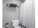 Neat bathroom featuring a white toilet, shower curtain, and towel rack in a neutral color scheme at 7531 Mohawk Ln, Indianapolis, IN 46260