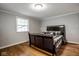 Cozy bedroom featuring hardwood floors, a large window, and a comfortable bed with stylish bedding at 7531 Mohawk Ln, Indianapolis, IN 46260