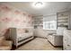 Charming Bedroom with a pink accent wall, built-in shelving, and a cozy armchair at 7531 Mohawk Ln, Indianapolis, IN 46260
