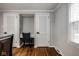 Bedroom with gray walls and white doors, with a small desk space and hardwood floors at 7531 Mohawk Ln, Indianapolis, IN 46260