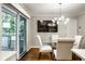 Elegant dining area featuring a modern chandelier, hardwood floors, and a door to the outside at 7531 Mohawk Ln, Indianapolis, IN 46260