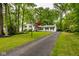 Charming home with a long driveway, well-manicured lawn, mature trees, and dark shutters at 7531 Mohawk Ln, Indianapolis, IN 46260
