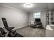 Carpeted home gym space featuring a metal desk, shelving, and exercise equipment at 7531 Mohawk Ln, Indianapolis, IN 46260