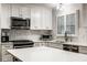 Beautiful kitchen featuring stainless steel appliances, marble backsplash, and white cabinets at 7531 Mohawk Ln, Indianapolis, IN 46260