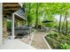 Inviting backyard featuring a hot tub and a patio area with an umbrella-covered table set amongst lush landscaping at 7753 Ivy Dr, Nineveh, IN 46164