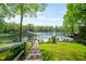 Lush backyard with a wooden walkway leading to a private dock on a serene lake at 7753 Ivy Dr, Nineveh, IN 46164