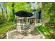 Outdoor patio area with table set, grill, and verdant foliage, set against a lakeside backdrop at 7753 Ivy Dr, Nineveh, IN 46164