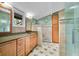Well-lit bathroom with tiled floors, a large mirror, wooden cabinetry and a glass enclosed shower at 7753 Ivy Dr, Nineveh, IN 46164