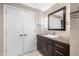 Bathroom with a dark vanity and a modern square mirror, features neutral toned tiling and door to closet at 7753 Ivy Dr, Nineveh, IN 46164