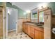 Stylish bathroom with tiled floors, wooden cabinets, a large mirror and natural light at 7753 Ivy Dr, Nineveh, IN 46164
