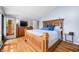 Bright bedroom with hardwood floors, natural light, and a wooden bed with blue decorative pillows at 7753 Ivy Dr, Nineveh, IN 46164
