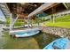Covered boat dock featuring two kayaks, boat lifts, and a peaceful waterfront setting at 7753 Ivy Dr, Nineveh, IN 46164