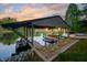 Covered boat dock at sunset with boat lift, ample space, and charming lake access at 7753 Ivy Dr, Nineveh, IN 46164