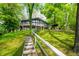 Charming hillside home with a full front porch and stairway access nestled amongst mature green trees at 7753 Ivy Dr, Nineveh, IN 46164