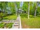 Charming hillside home with a full front porch and stairway access nestled amongst mature green trees at 7753 Ivy Dr, Nineveh, IN 46164