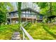 Charming hillside home with a full front porch and stairway access nestled amongst mature green trees at 7753 Ivy Dr, Nineveh, IN 46164