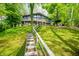 Charming hillside home with a full front porch and stairway access nestled amongst mature green trees at 7753 Ivy Dr, Nineveh, IN 46164