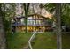 A two story home with large windows and stone accents is nestled among mature trees at 7753 Ivy Dr, Nineveh, IN 46164