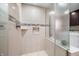 Tiled shower features pebble floor, niche storage, and glass partition, view into the laundry room at 7753 Ivy Dr, Nineveh, IN 46164