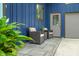 Relaxing outdoor space with two patio chairs sitting by the side entrance and gray garage door at 7753 Ivy Dr, Nineveh, IN 46164