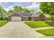 Charming brick home with a two-car garage, a well-manicured lawn, and a concrete driveway at 7835 Quail S Rdg, Plainfield, IN 46168