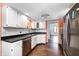 Efficient kitchen features white cabinets, stainless steel appliances, and ample countertop space, with hardwood flooring at 7835 Quail S Rdg, Plainfield, IN 46168