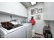 Organized laundry room with modern appliances and ample cabinet space at 7835 Quail S Rdg, Plainfield, IN 46168