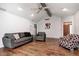 Cozy living room with hardwood floors, ceiling fan, neutral paint, and comfortable seating with sofa and chair at 7835 Quail S Rdg, Plainfield, IN 46168