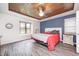 Bedroom with a blue accent wall, wood ceiling, and large window at 7835 Quail S Rdg, Plainfield, IN 46168