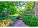 Lush backyard featuring a brick path, mature trees and a playset at 8065 Bayberry Ct, Indianapolis, IN 46250