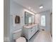 Well-lit bathroom with a double sink vanity, marble countertop, tiled floors, and a toilet at 8065 Bayberry Ct, Indianapolis, IN 46250