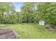 Lush backyard with a shed, fire pit, and verdant trees at 809 Iron Bridge Rd, Cicero, IN 46034