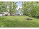 Spacious backyard with verdant trees, a fire pit, and lots of greenery at 809 Iron Bridge Rd, Cicero, IN 46034