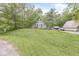 A-frame house on a large lot with a well-kept lawn, trees, and detached garage, creating a park-like setting at 809 Iron Bridge Rd, Cicero, IN 46034