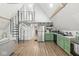 Open-concept kitchen with stainless steel appliances, green cabinets, and a modern spiral staircase at 809 Iron Bridge Rd, Cicero, IN 46034