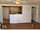 Open living room featuring wood-look flooring, a ceiling fan, and view into the kitchen and bathroom areas at 909 Hickory St, Anderson, IN 46012
