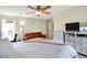 Spacious bedroom features a large bed, a ceiling fan, a dresser, and a comfortable couch for relaxing at 9255 Fireside Dr, Indianapolis, IN 46250